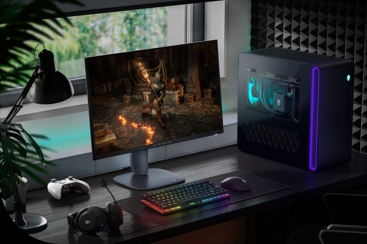 Игровой монитор Alienware 27 на игровом столе, оборудованном настольным компьютером, наушниками, игровым контроллером, клавиатурой и мышью.